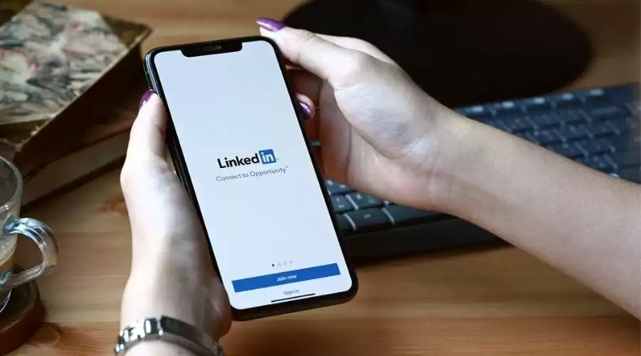 Žena drži mobitel u ruci s upaljenom aplikacijom LinkedIn.